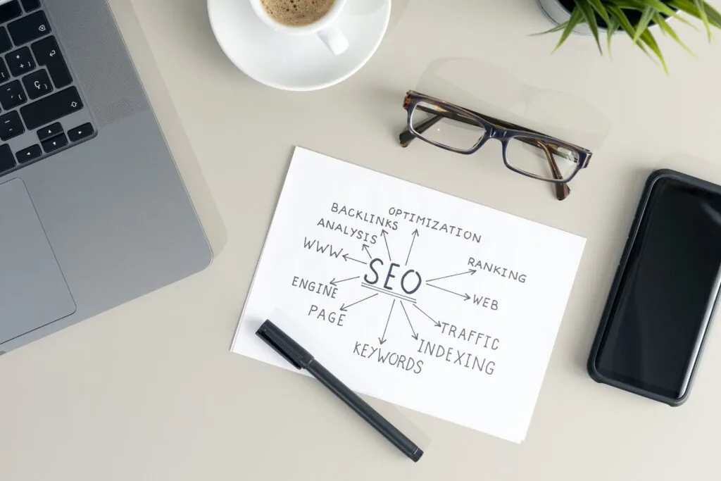 SEO keyword planning notebook beside a phone and laptop